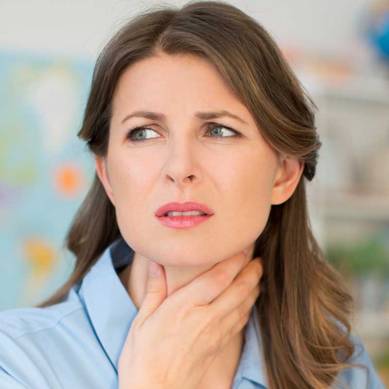 Woman holding her throat, wondering what causes esophageal disorders